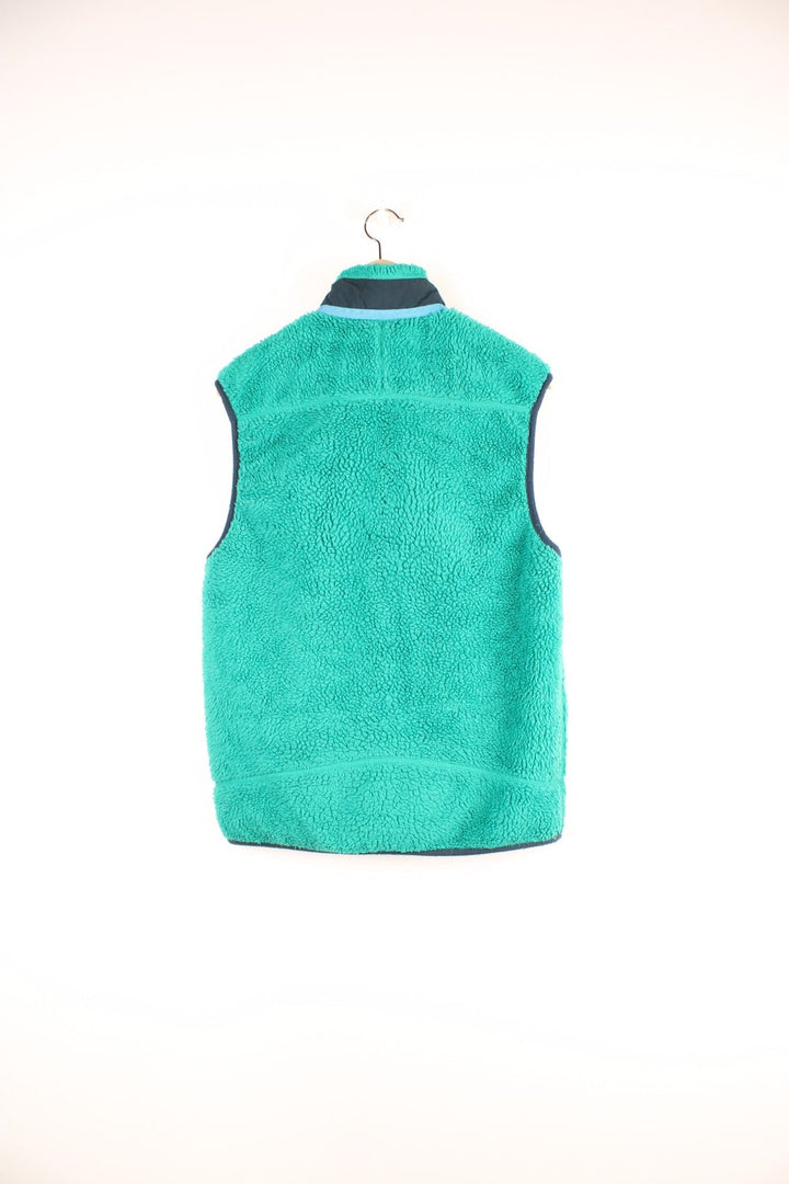 Green Patagonia zip-up fleece gilet with blue accents, three zipped pockets and a logo patch.  