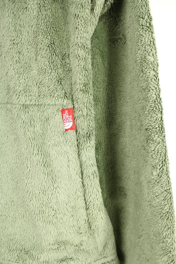 Green fluffy The North Face fleece with 1/4 zip closure, pouch pocket, and a red logo tag.  