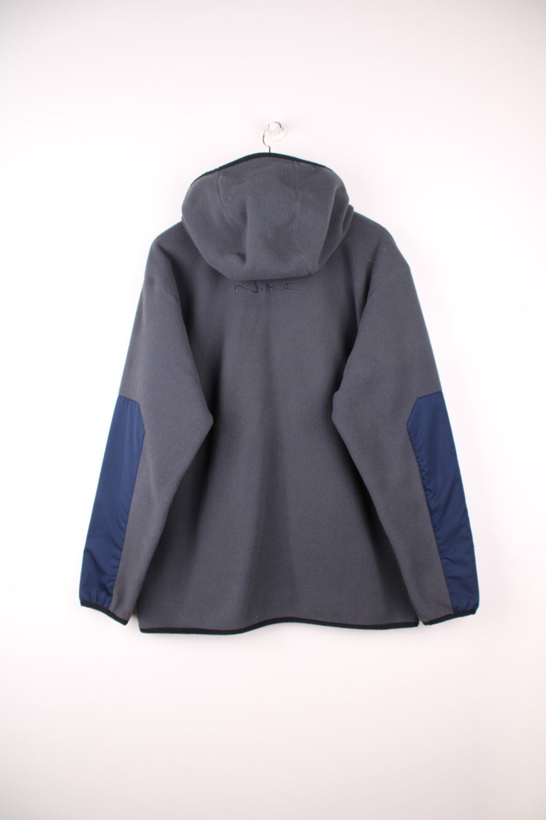 Dark grey Nike fleece quarter zip hoodie with navy blue contrast front pocket and sleeve panels, an embroideres swoosh logo on the front, and Nike spellout embroidered on the back. 