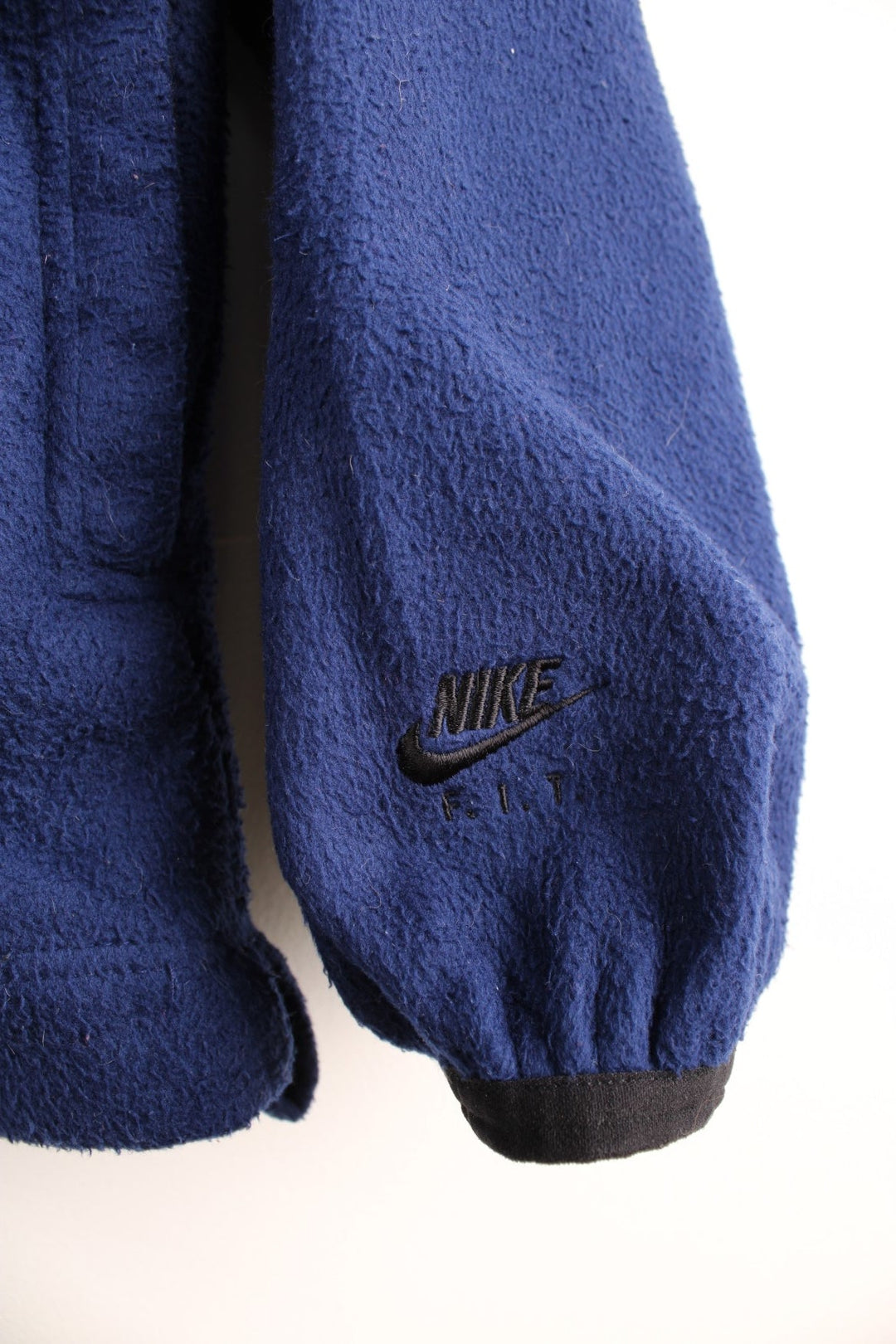 Dark blue Nike ACG 1/2 zip fleece with three pockets and an embroidered logo on the chest and sleeve.  