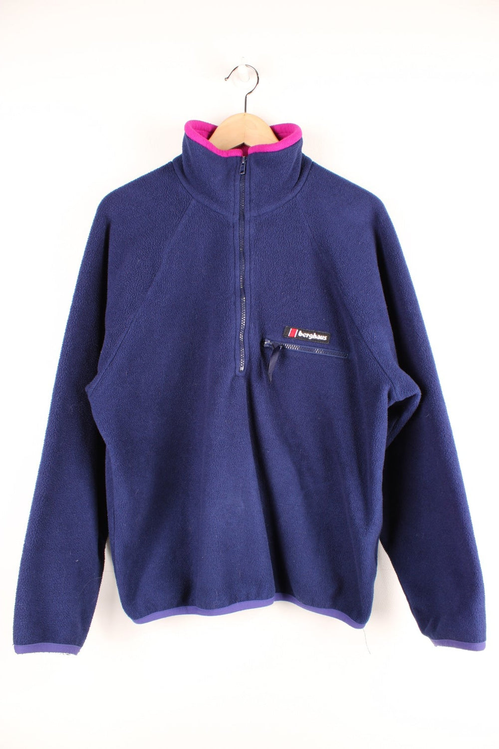 Dark blue Berghaus 1/2 zip fleece with pink around the collar, a zipped pocket, and an embroidered logo.  