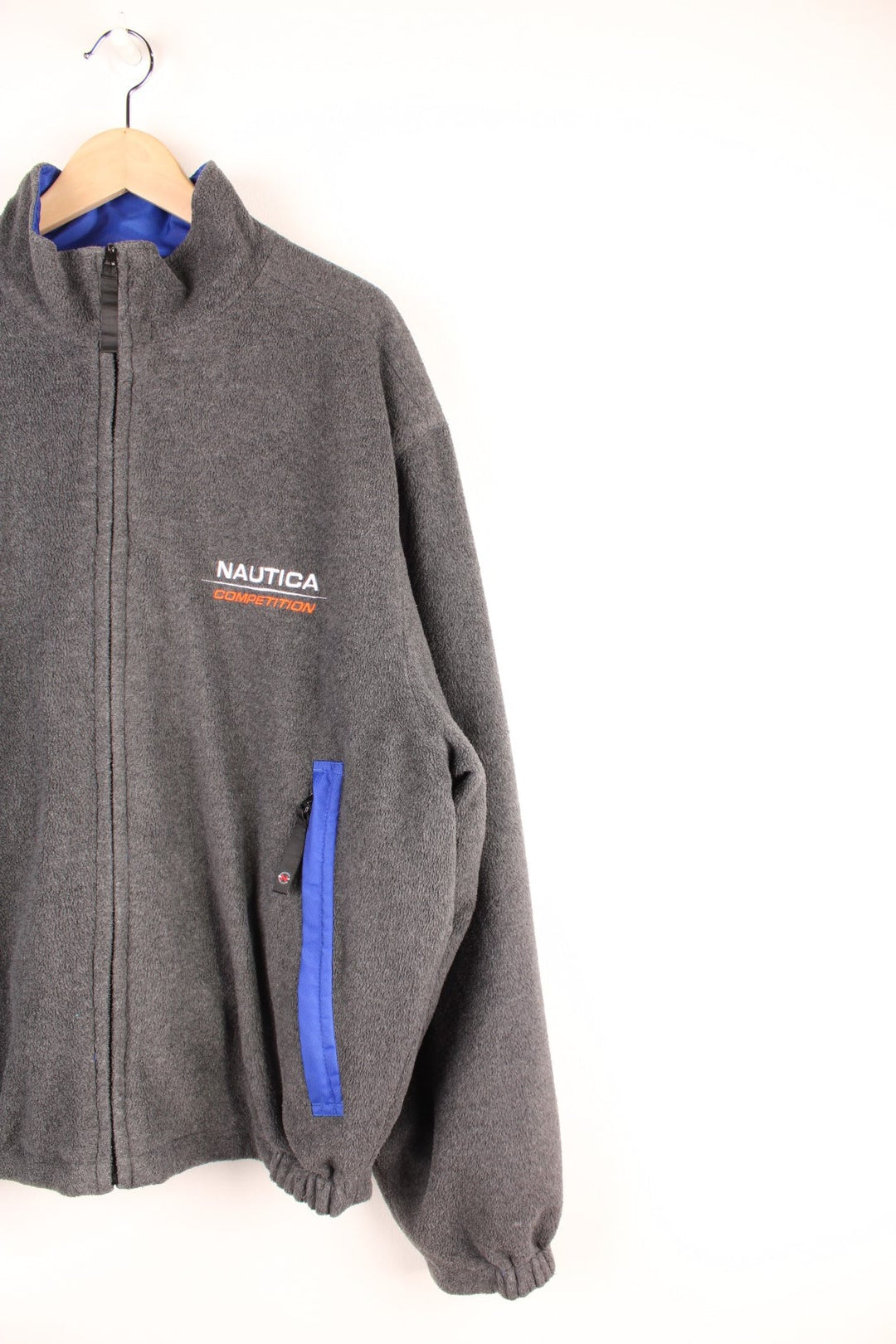 Grey Nautica reversible fleece jacket with a shower-proof side in blue and a fleece side in grey. Zipped pockets and embroidered logos on both sides. 