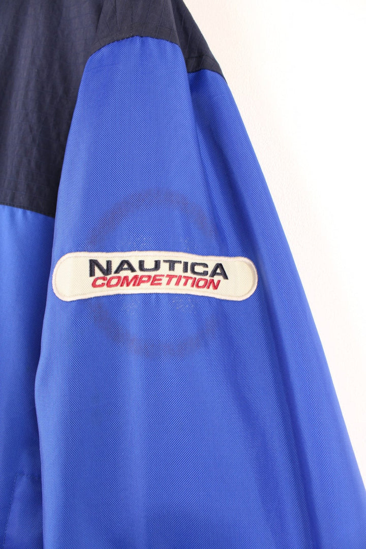 Grey Nautica reversible fleece jacket with a shower-proof side in blue and a fleece side in grey. Zipped pockets and embroidered logos on both sides. 