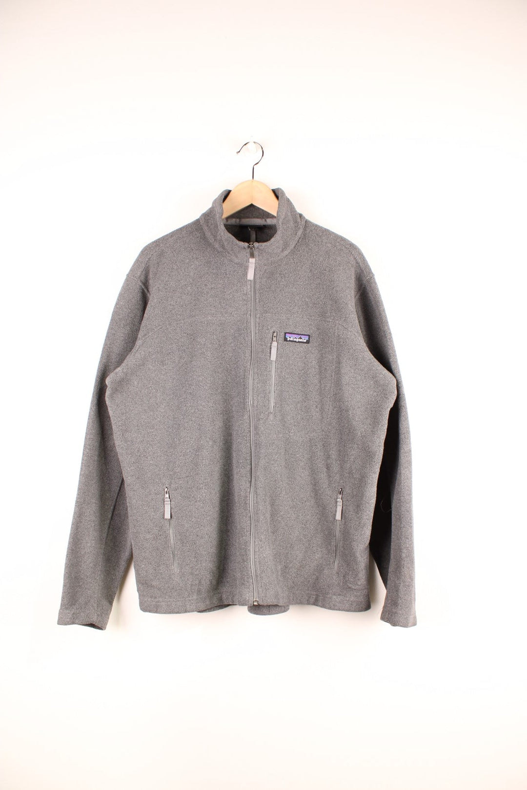 Grey Patagonia Synchilla zip-up fleece with three zipped pockets and an embroidered logo on the chest.