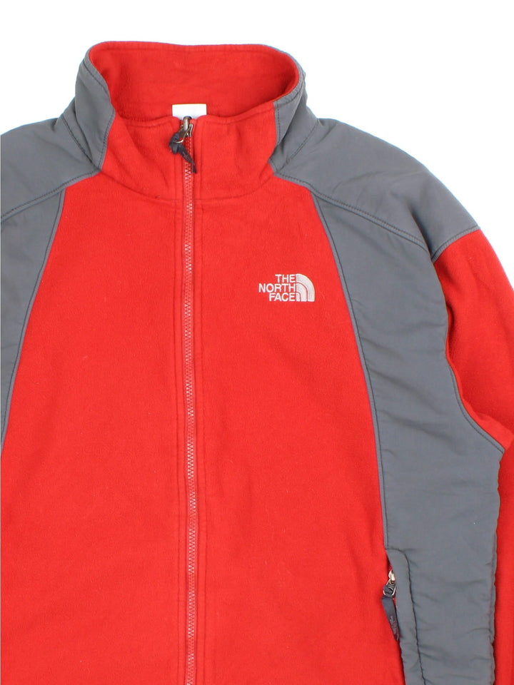 The North Face Fleece in a red colourway with grey panelling down the sides and shoulders, Full zip with multiple pockets and classic small logo on the front.