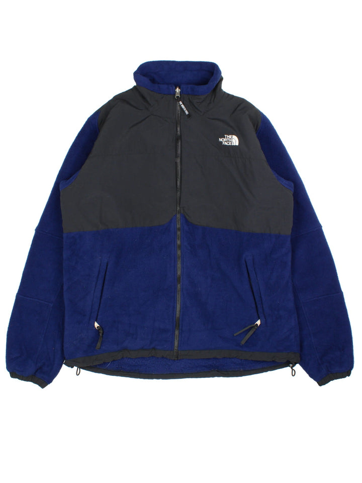 The North Face Denali Fleece in a blue & black colourway. Full zip with multiple pockets on the sides and under arms. Drawstring hem, elbow patches and classic small logo on the front and back.