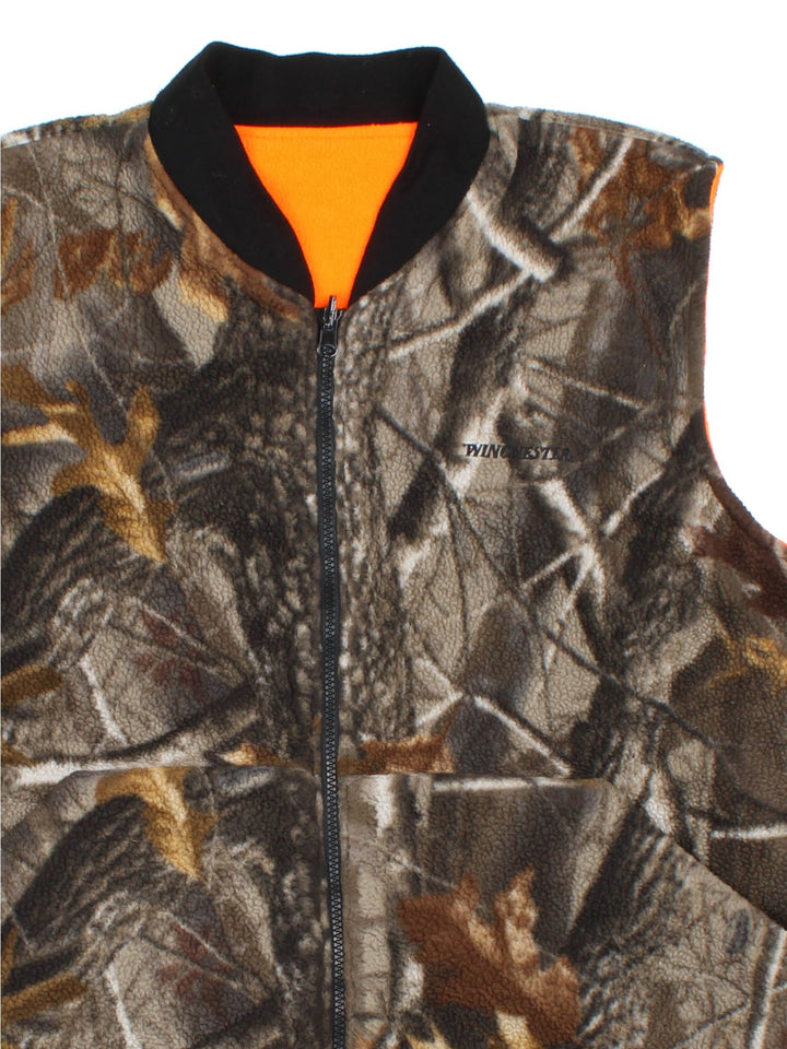 Vintage Winchester Reversable Fleece Gilet in a brown colourway. Camo print with orange reversable side, Full zip with two front pockets. Small logo on chest.