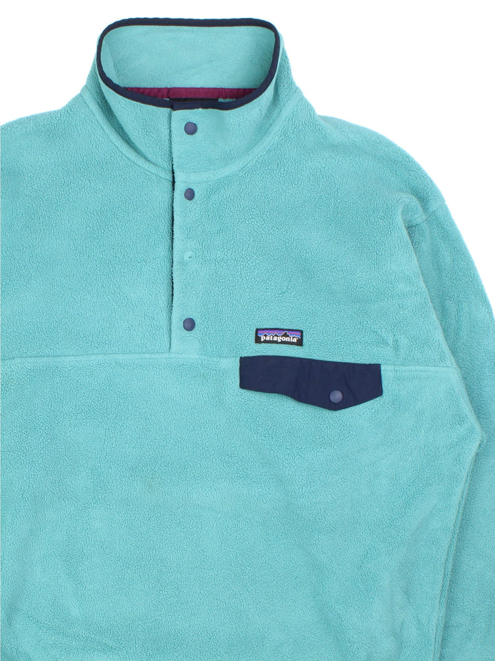 Patagonia Synchilla Snap-T Fleece in a blue colourway with button down front and small button pocket. Small classic logo on the front.