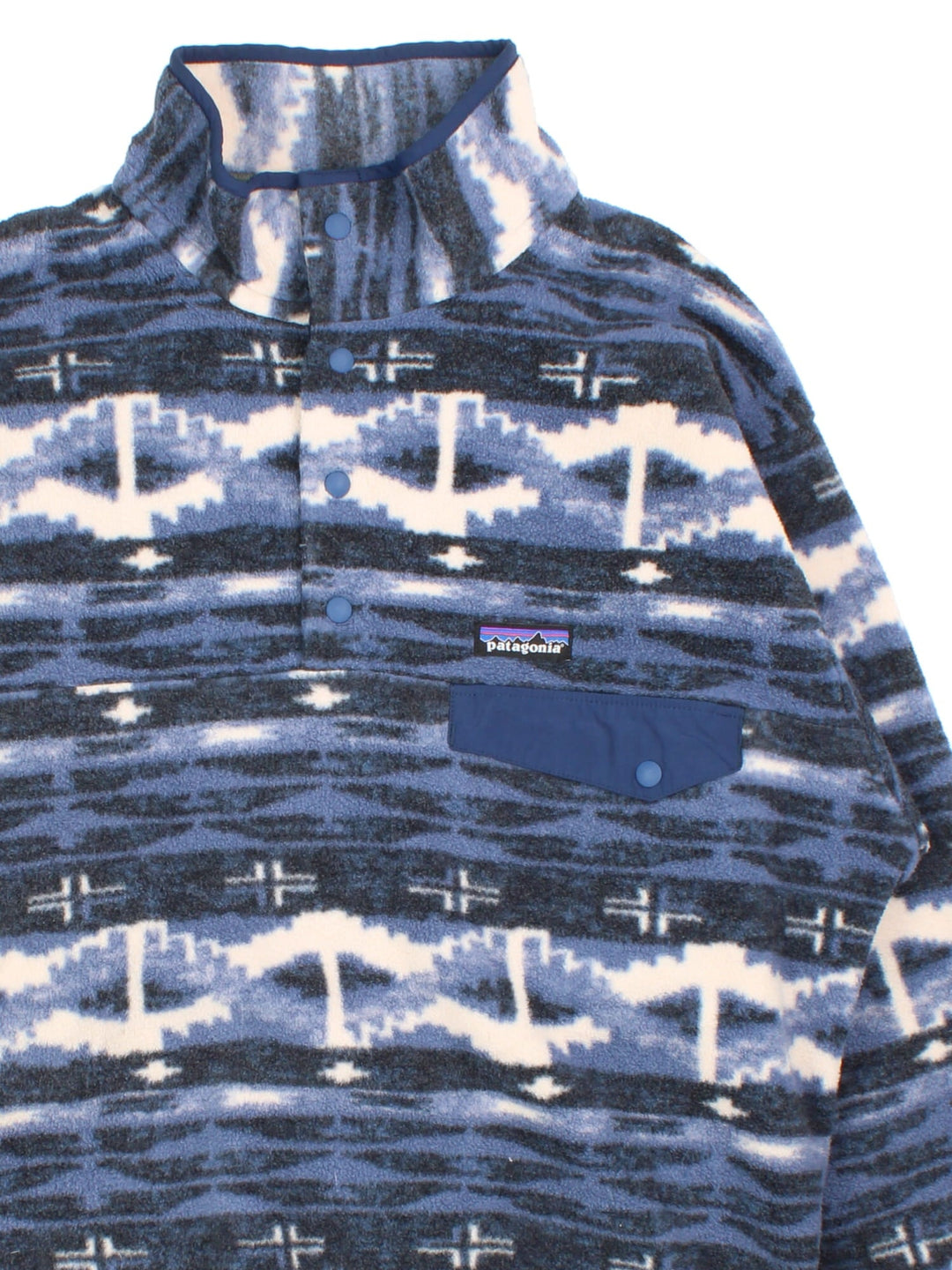 Patagonia Synchilla Snap-T Fleece in a blue colourway with blue tonal pattern. Button down front and small button pocket. Small classic logo on the front .