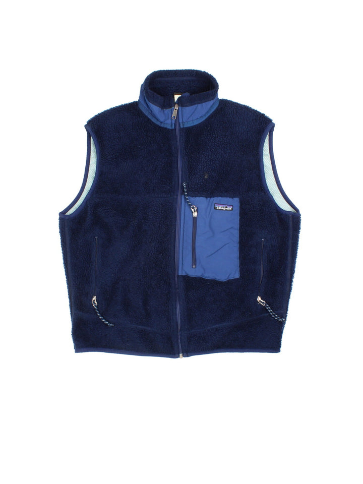 Patagonia Fleece Gilet in a blue colourway. Full zip with multiple zip pockets and small classic logo on the front.