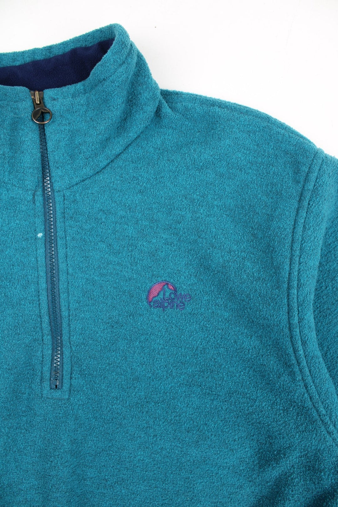 Vintage Lowe Alpine Pullover Fleece in a blue colourway. Half zip up and has side pockets, and the logo embroidered on the front.