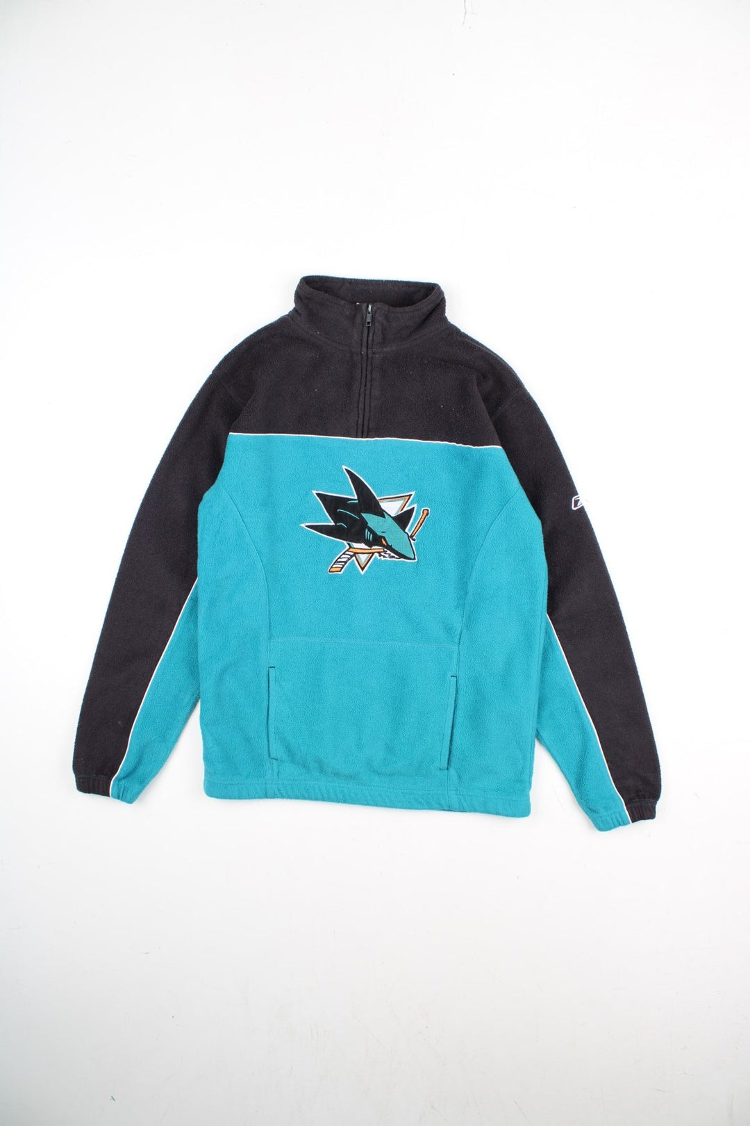 Vintage Reebok San Jose Sharks NHL Pullover Fleece in a blue and black colourway. 1/4 zip up and has pouch pocket, and the team logo embroidered on the front and Reebok logo on the left sleeve.