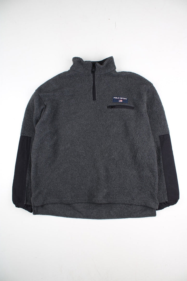 Vintage Ralph Lauren Polo Sport Fleece in a grey colourway with black panels on the sleeves and on the back. 1/4 zip up and has a chest pocket, and the logo embroidered on the front.