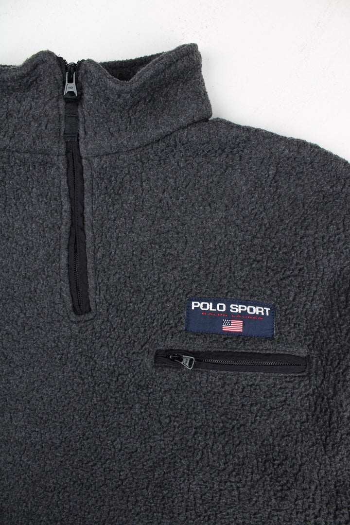 Vintage Ralph Lauren Polo Sport Fleece in a grey colourway with black panels on the sleeves and on the back. 1/4 zip up and has a chest pocket, and the logo embroidered on the front.