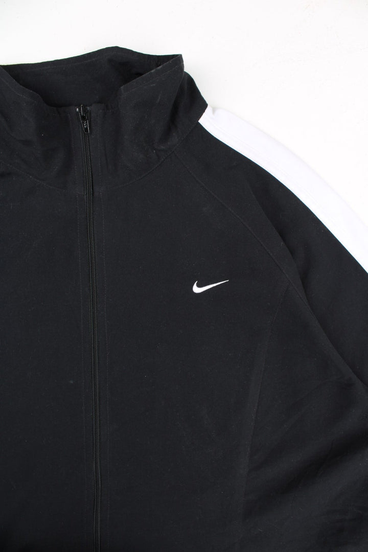 Vintage Nike Tracksuit Jacket in a black and white colourway. Zips up and has side pockets, and the logo embroidered on the front.