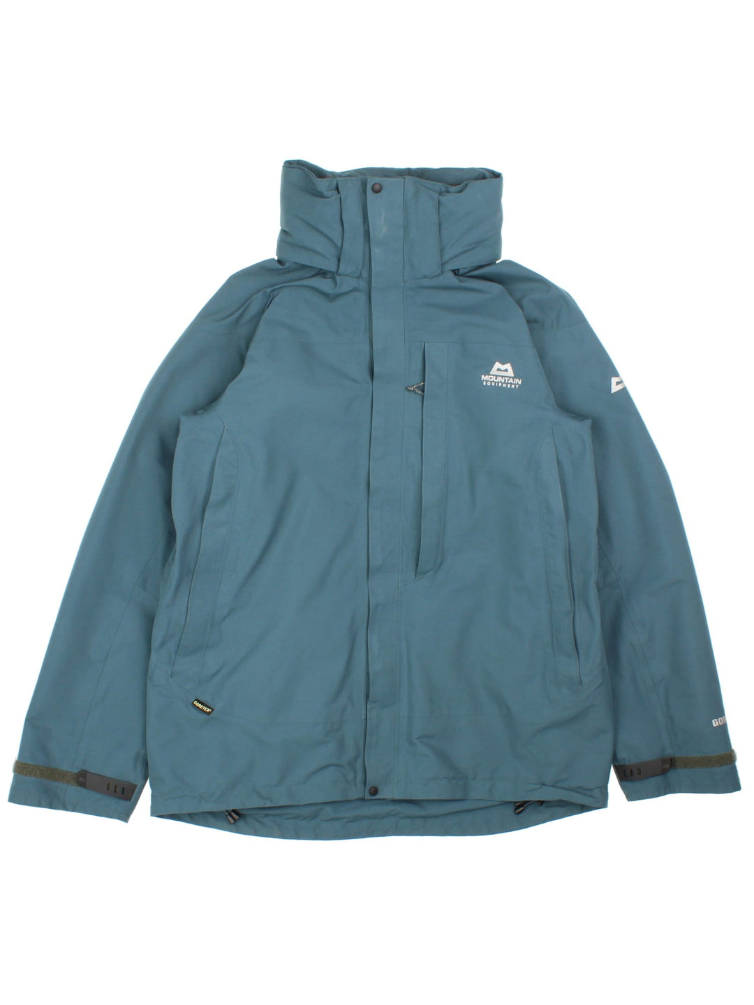 Mountain Equipment Coat in a green colourway. Multiple zip pockets, Gore-tex technology, fold away hood and drawstring hem. Small logo on front and sleeve.