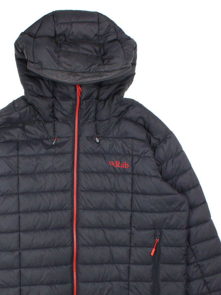 Rab Nebula Puffer Coat in a black colourway. Full red zip detail and multiple pockets on front with a drawstring hood.