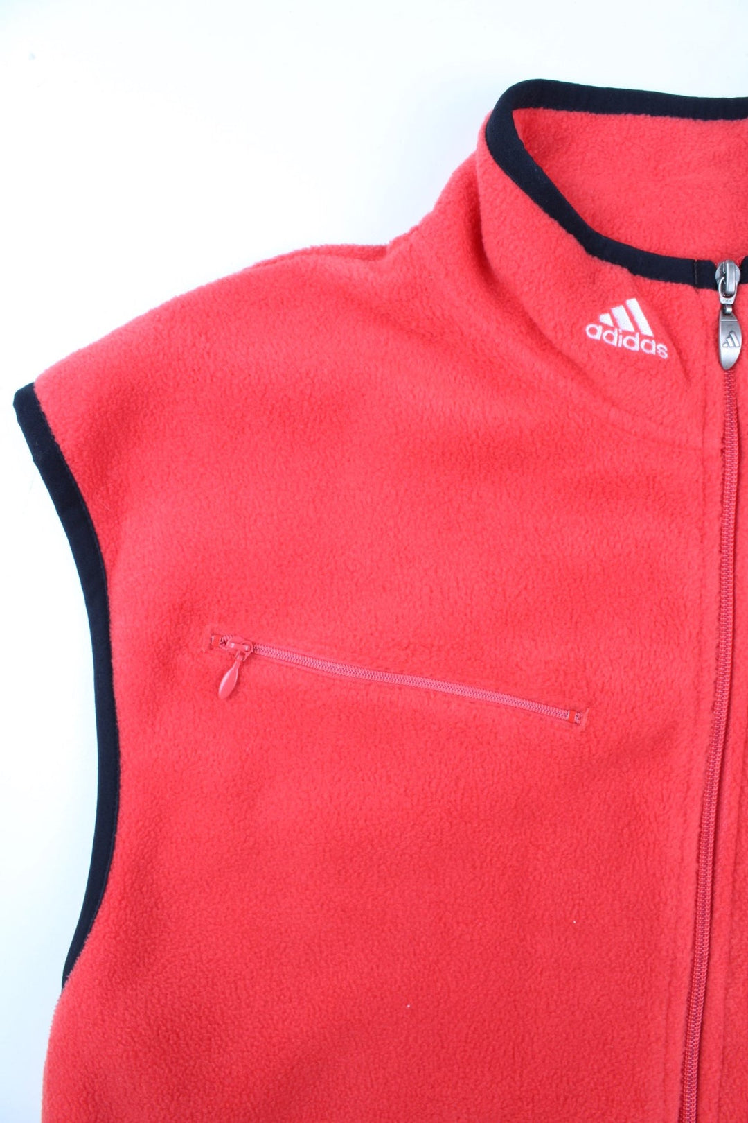 Vintage Adidas Fleece Vest in a red colourway, with black piping. Zip up with side pockets, and has the logo embroidered on the neckline.