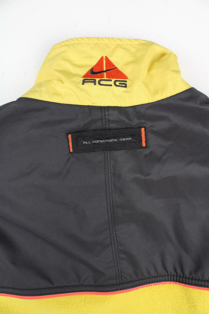 Vintage Nike ACG Gilet in a yellow/black colourway. Zip up with side/back zip pockets and fleece lining, and has the logo embroidered on the front and back.