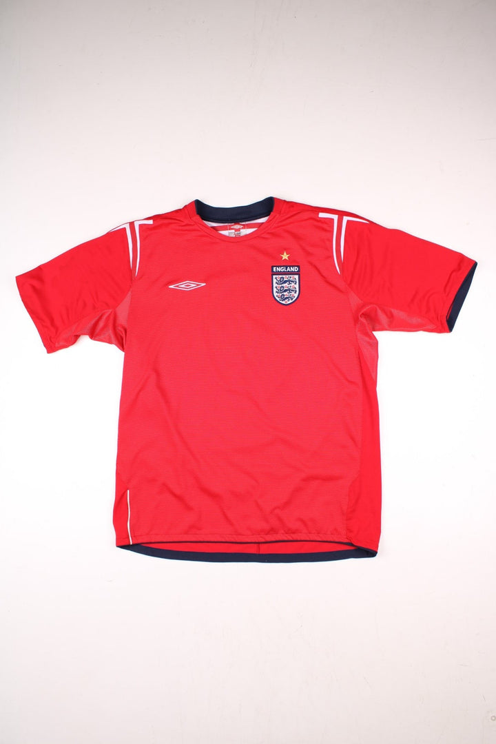 England 2004/06 Umbro Football Shirt in the red away kit colourway, features embroidered logos and badge on the front, and Paul Scholes number 8 printed on the back.