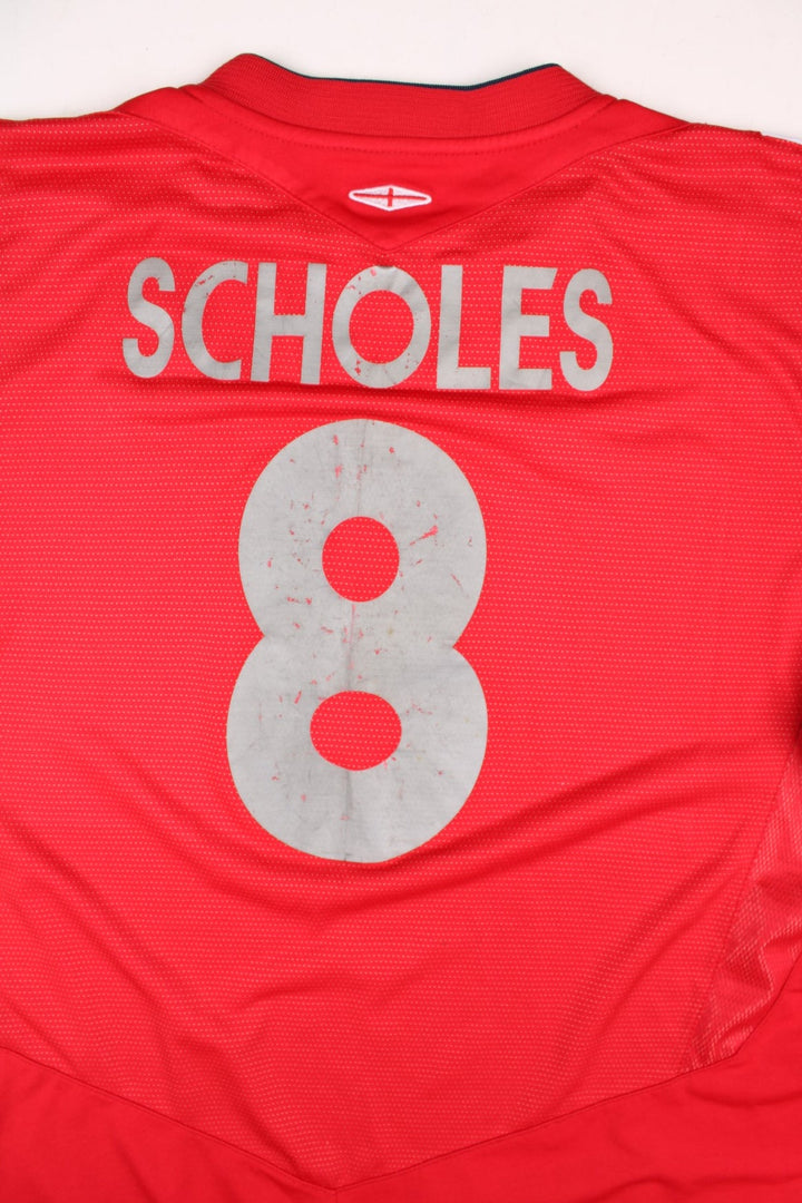 England 2004/06 Umbro Football Shirt in the red away kit colourway, features embroidered logos and badge on the front, and Paul Scholes number 8 printed on the back.