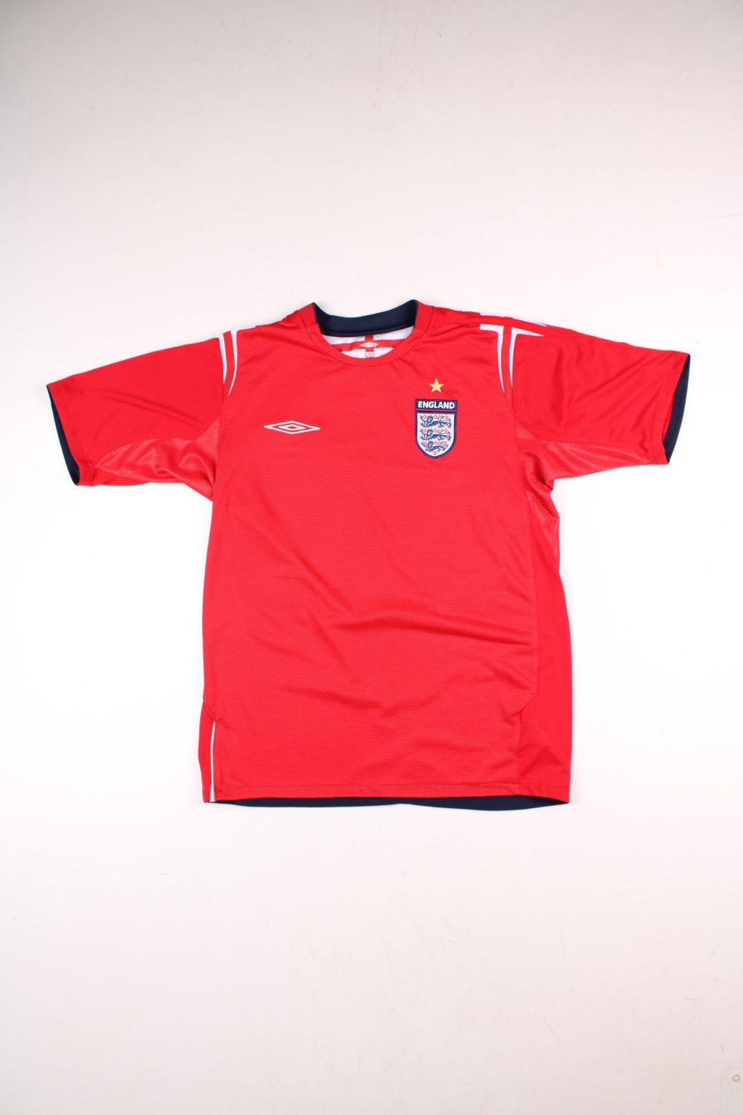 England 2004/06 Umbro Football Shirt in the red away kit colourway, features embroidered logos and badge on the front.