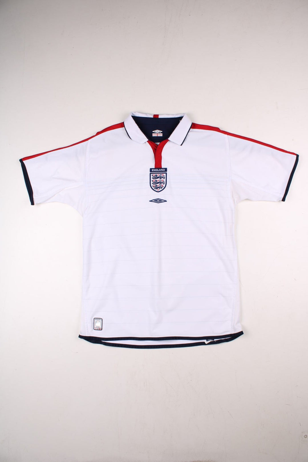 England 2004/06 Umbro Football Shirt in the white home kit colourway, features embroidered logos and badge on the front with reversible option.