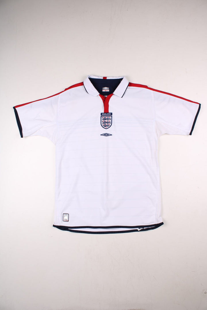 England 2004/06 Umbro Football Shirt in the white home kit colourway, features embroidered logos and badge on the front with reversible option.