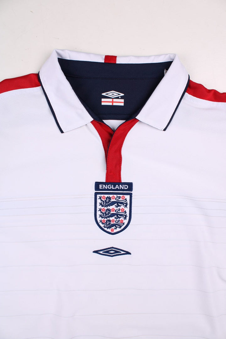 England 2004/06 Umbro Football Shirt in the white home kit colourway, features embroidered logos and badge on the front with reversible option.