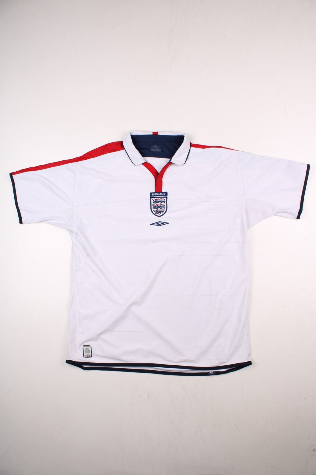 England 2004/06 Umbro Football Shirt in the white home kit colourway, features embroidered logos and badge on the front with reversible option.