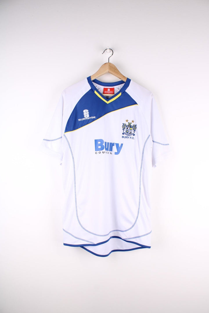 Vintage Bury FC 2012/13 Football Shirt in the white and blue home kit colourway, features embroidered logo and badge on the front, and on the back has Morley number 40 printed alongside team signatures.