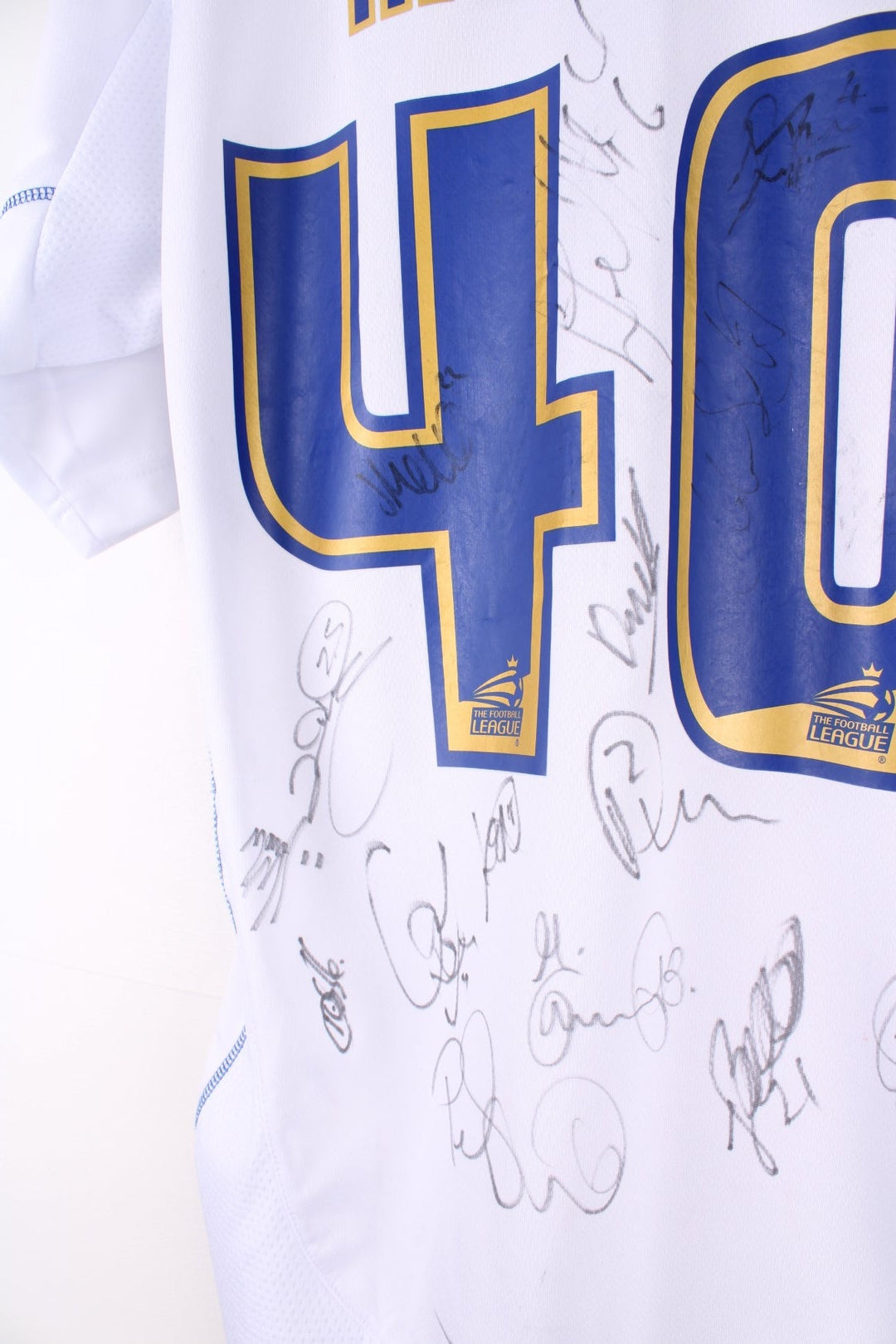 Vintage Bury FC 2012/13 Football Shirt in the white and blue home kit colourway, features embroidered logo and badge on the front, and on the back has Morley number 40 printed alongside team signatures.