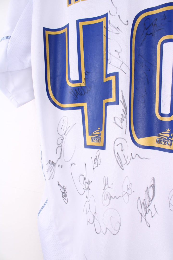 Vintage Bury FC 2012/13 Football Shirt in the white and blue home kit colourway, features embroidered logo and badge on the front, and on the back has Morley number 40 printed alongside team signatures.