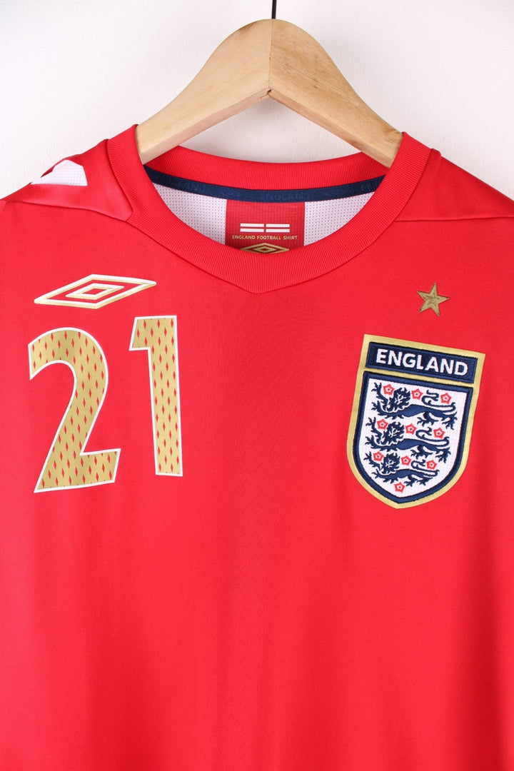 England 2006/08  Football Shirt in the  away kit colourway, features embroidered logos and badge on the front, and has Crouch number 21 on the back.