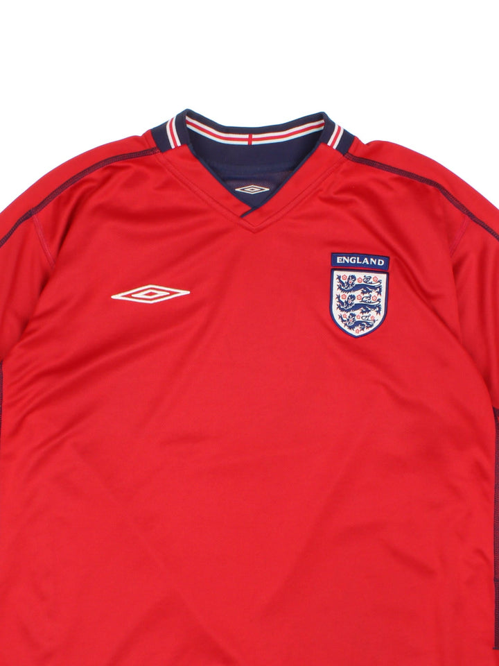 England 2002/04 Umbro Reversible Football Shirt in either a red or blue away kit colourway options, features embroidered logos and badge on the front.