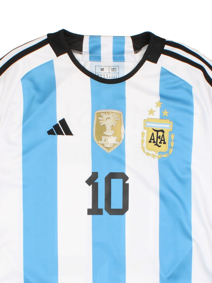 Argentina 2022 World Cup Adidas Football Shirt in the blue and white home kit colourway, features embroidered logos and badge on the front, and Lionel Messi number 10 printed on the back.