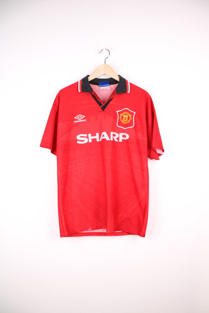 Manchester United 1994/95 Umbro Football Shirt in the red home colourway, features embroidered logo and badge on the front.