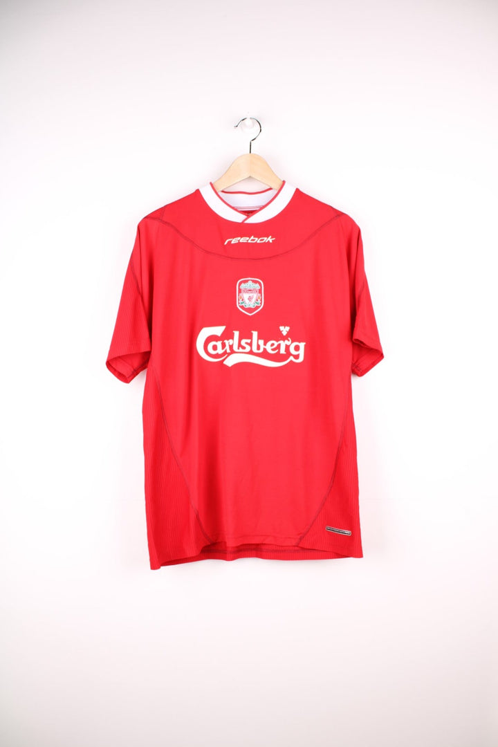 Liverpool 2002/04 Reebok Football Shirt in the red home colourway, features embroidered logo and badge on the front, and has Harry Kewell number 7 printed on the back.