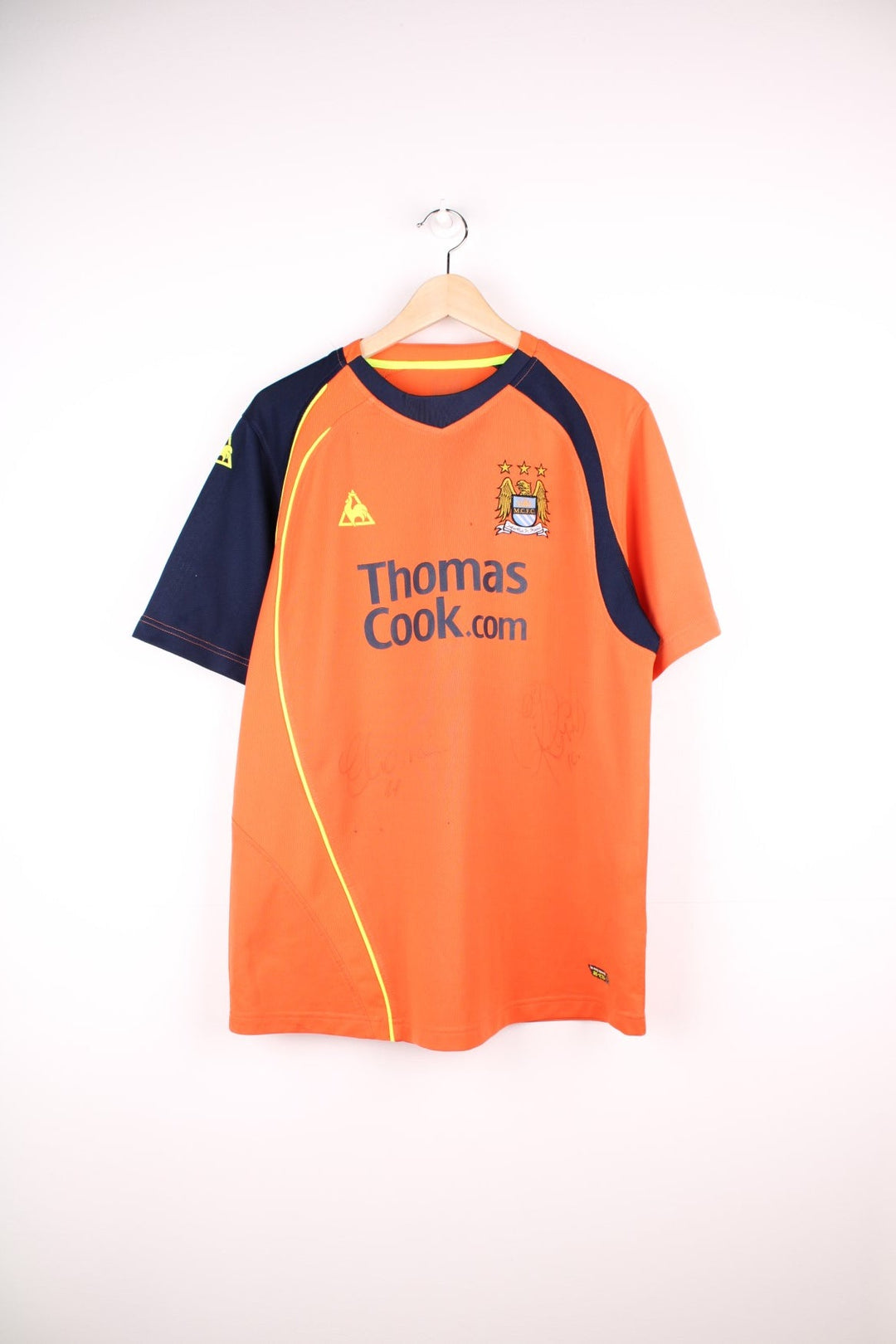 Manchester City 2008/09 Le Coq Sportif Football Shirt in the orange third kit colourway, features embroidered logo and badge on the front, and is signed by Elano number 11 and Robinho number 10.