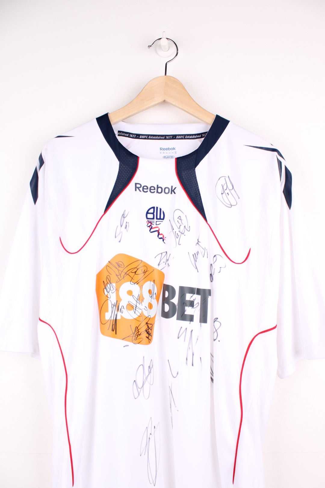 Bolton Wanderers 2010/11 Team Signed  Football Shirt in the  home kit colourway, features embroidered logo and badge on the front, as well as signatures all over.