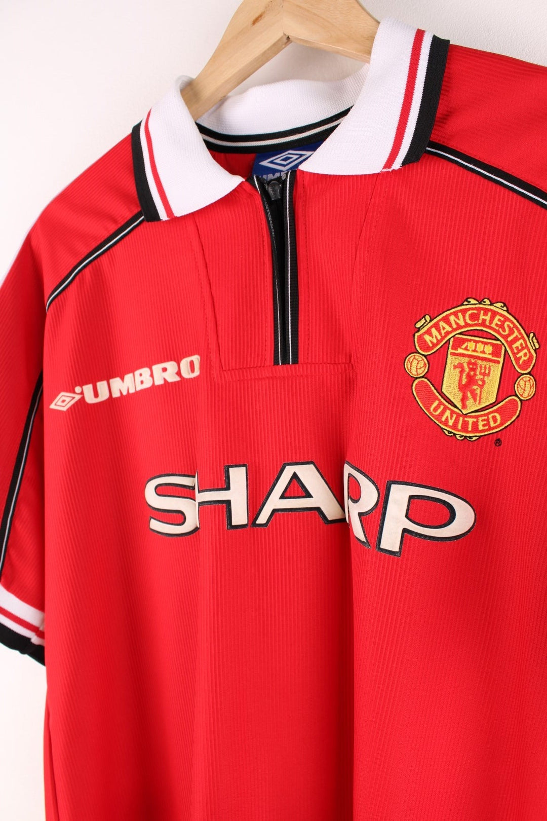 Manchester United 1998/99  Football Shirt in the  home kit colourway, features embroidered logos and badge on the front, zip up collar, and United number 1 printed on the back.