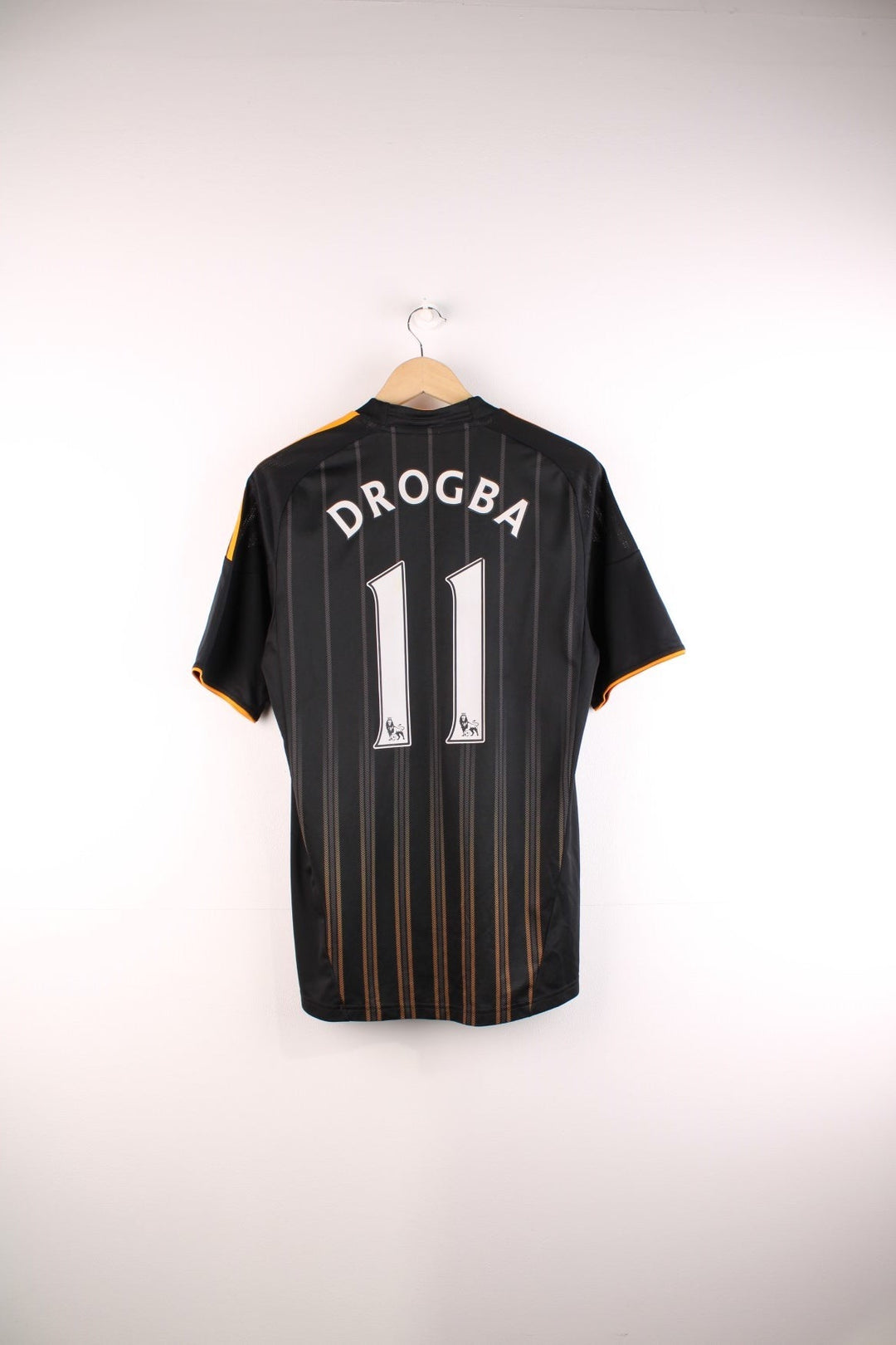 Chelsea 2010/11  Football Shirt in the  and orange away kit colourway, features embroidered logos and badge on the front and Didier Drogba number 11 printed on the back.