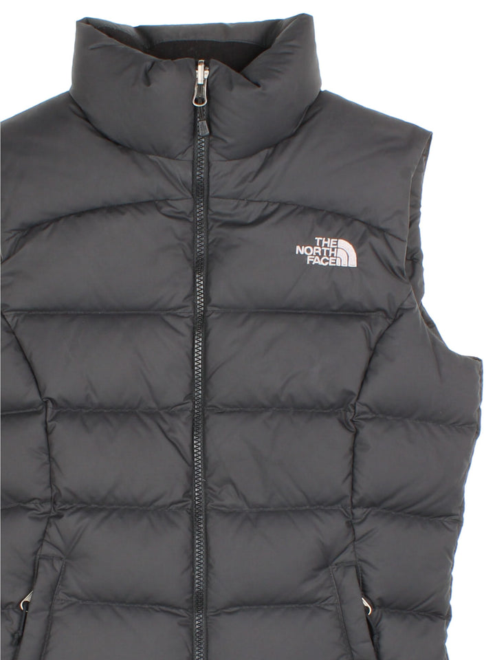 The North Face Down Puffer Gilet in a black colourway. Zips up and has side pockets, insulated lining, and has the logo embroidered on the front and back.