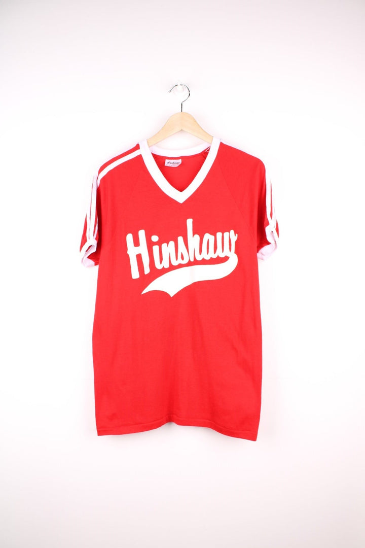 Vintage 70's Hinshaw Baseball T-Shirt in a red and white colourway, has a v neck collar, stripes going down the sleeves, and 'Hinshaw' spell out printed on the front as well as the number 3 on the back. 