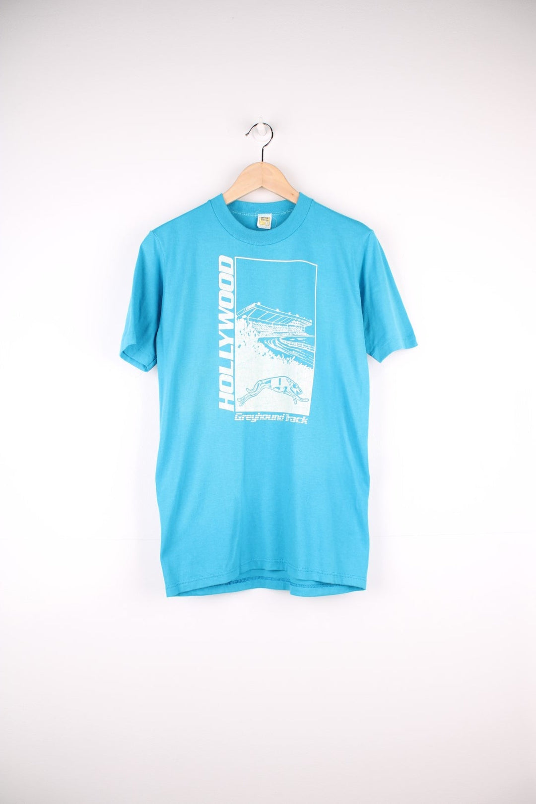 Vintage Hollywood Greyhound Track Racing T-Shirt in a blue and white colourway with graphic print and spell out on the front, single stitch T-Shirt with a Velva Sheen tag. 