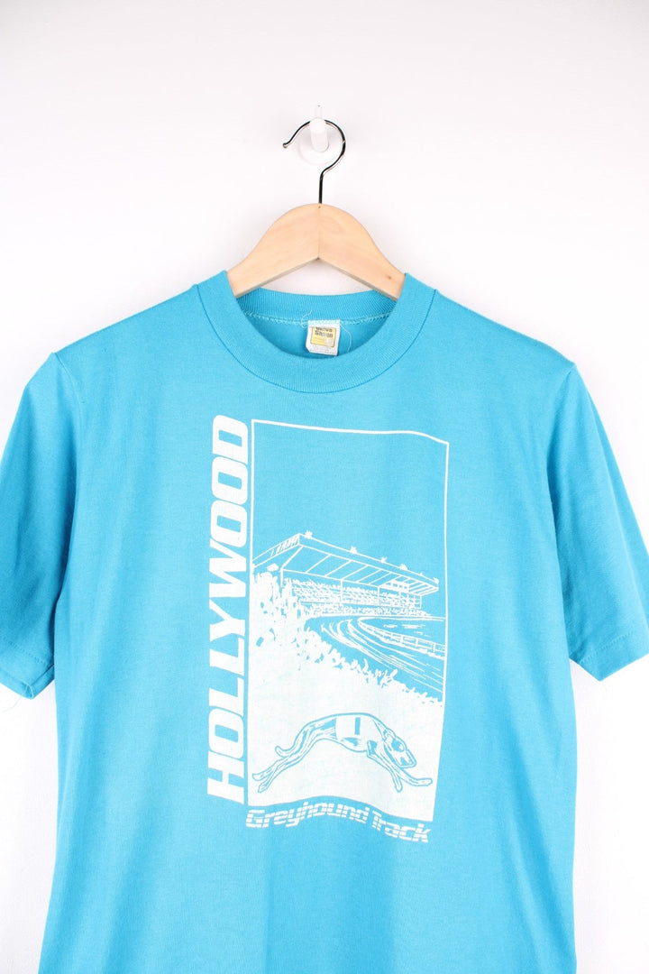 Vintage Hollywood Greyhound Track Racing T-Shirt in a blue and white colourway with graphic print and spell out on the front, single stitch T-Shirt with a Velva Sheen tag. 