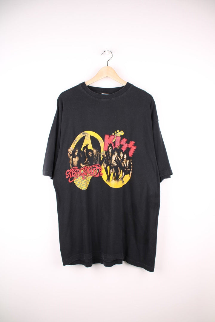 Vintage 2003 Aerosmith x Kiss Tour T-Shirt in black, yellow and red colourway with the bands name and picture printed on the front and all the tour dates on the back. 