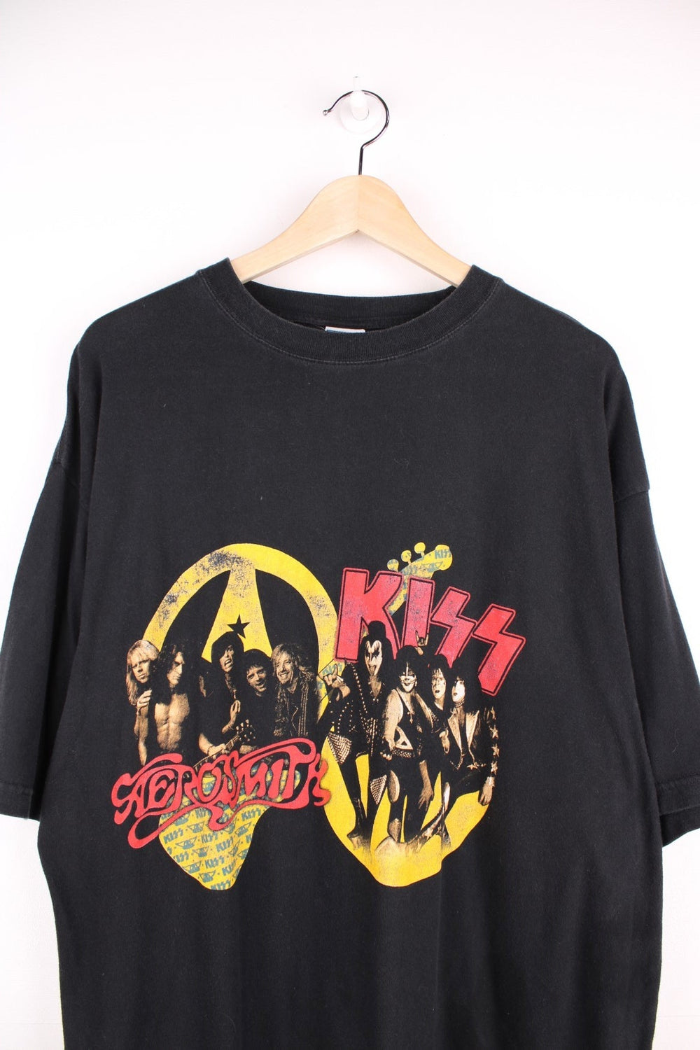 Vintage 2003 Aerosmith x Kiss Tour T-Shirt in black, yellow and red colourway with the bands name and picture printed on the front and all the tour dates on the back. 