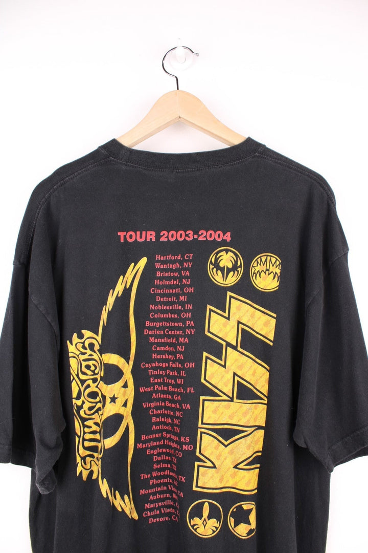 Vintage 2003 Aerosmith x Kiss Tour T-Shirt in black, yellow and red colourway with the bands name and picture printed on the front and all the tour dates on the back. 