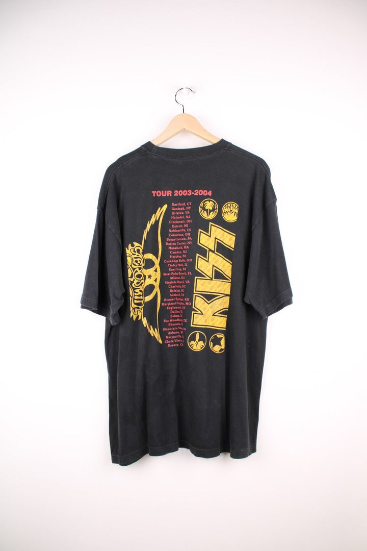 Vintage 2003 Aerosmith x Kiss Tour T-Shirt in black, yellow and red colourway with the bands name and picture printed on the front and all the tour dates on the back. 